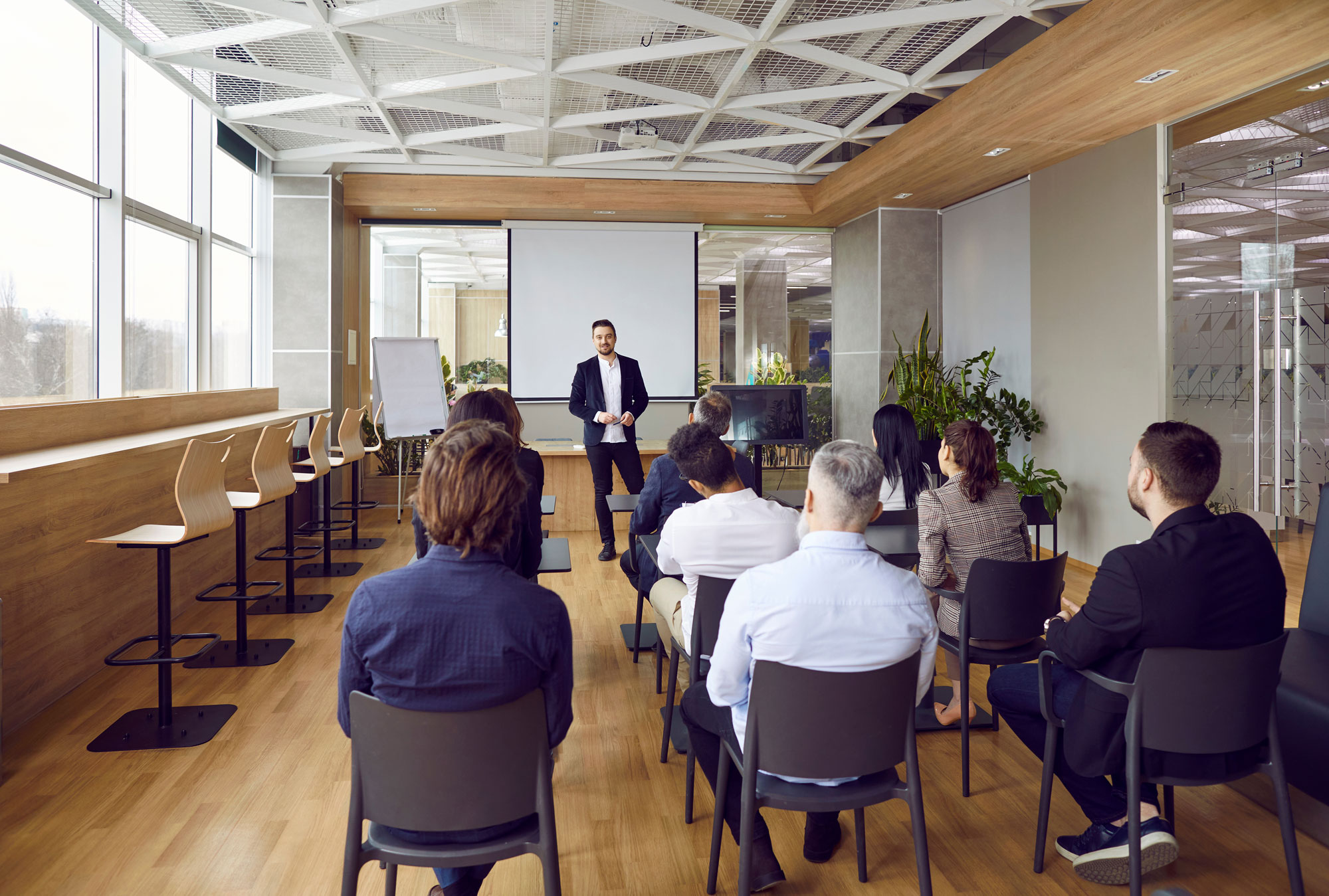 Ein Berater der KKU in einem Konferenzraum hält ein Coaching für eine Gruppe von Mitarbeitern