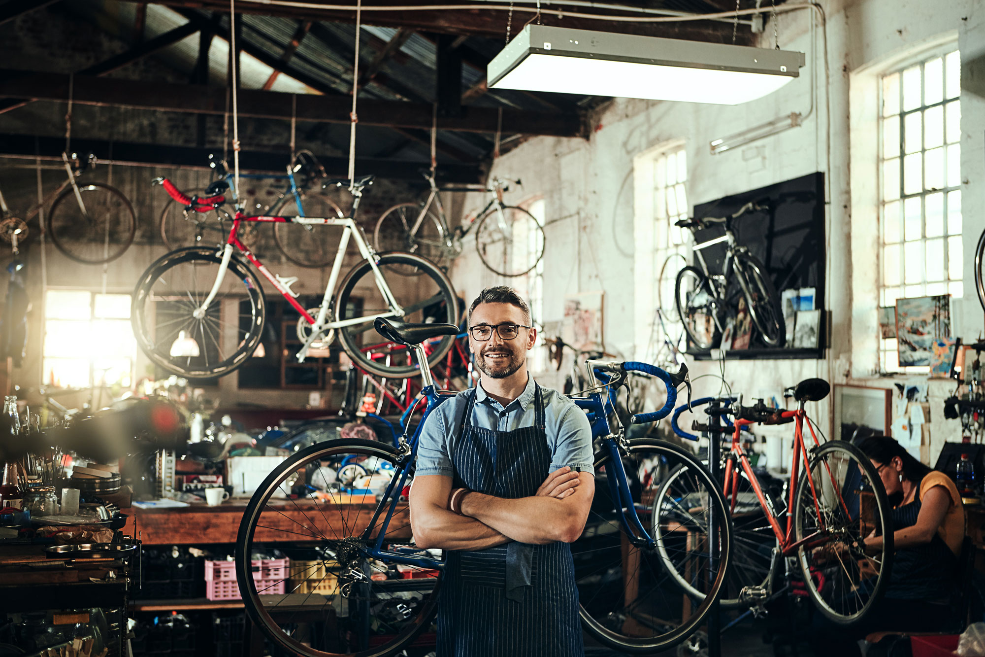 Eigentümer einer kleinen Fahrradwerkstatt mit selbstsicherem Blick in die Kamera