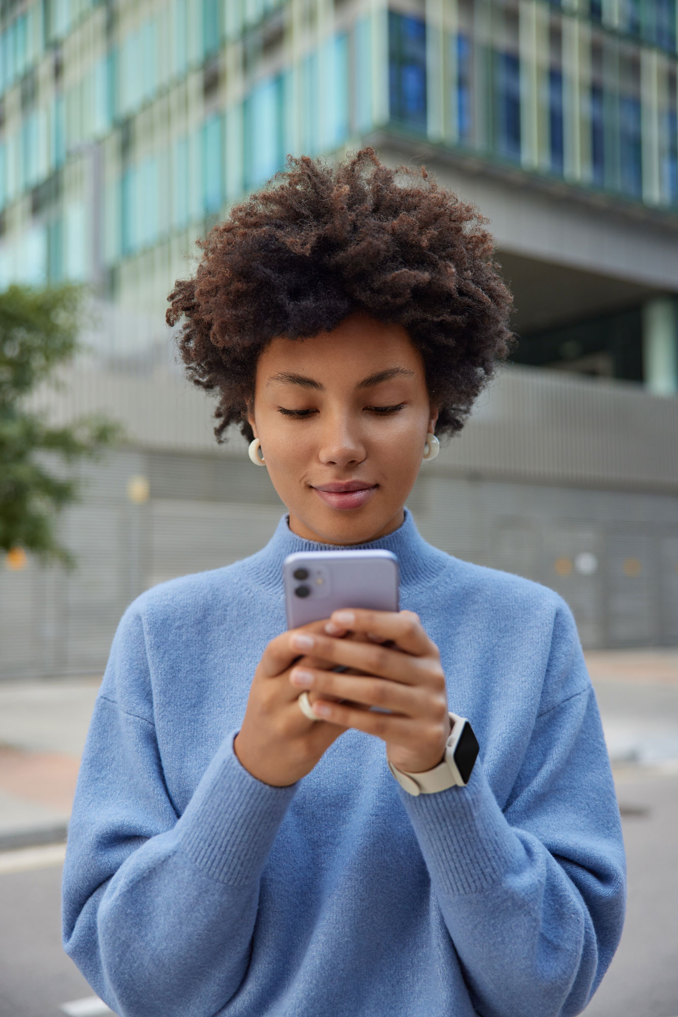 Junge Dame mit gesenktem Blick auf Ihr IPhone